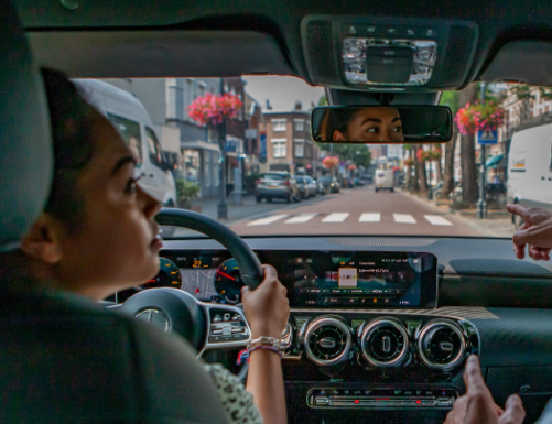 Leerling achter het stuur met instructeur in de lesauto